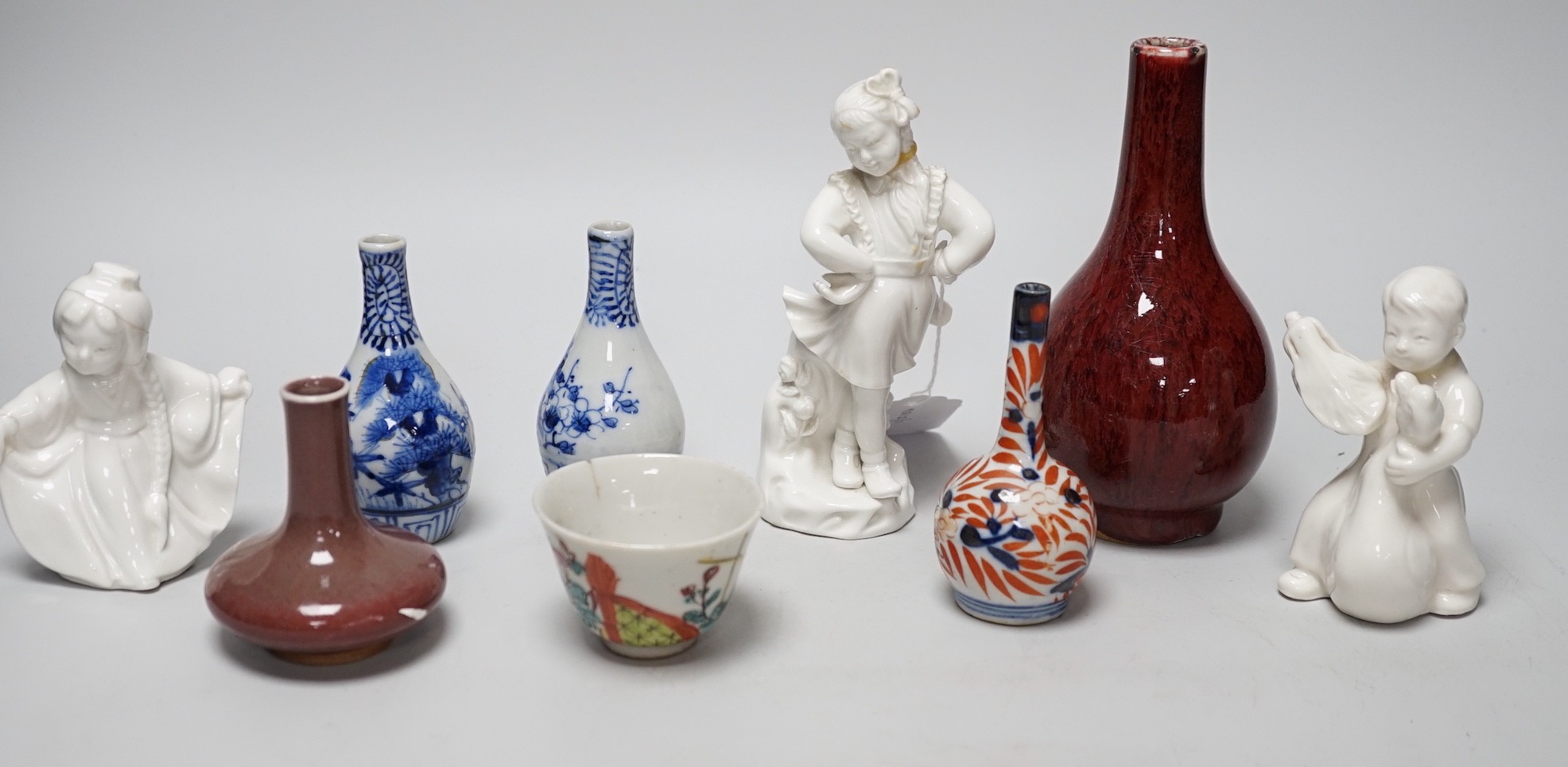 A Chinese sang de boeuf bottle neck vase, together with four Chinese miniature vases, three Chinese figures and a Chinese tea bowl, tallest 15cm